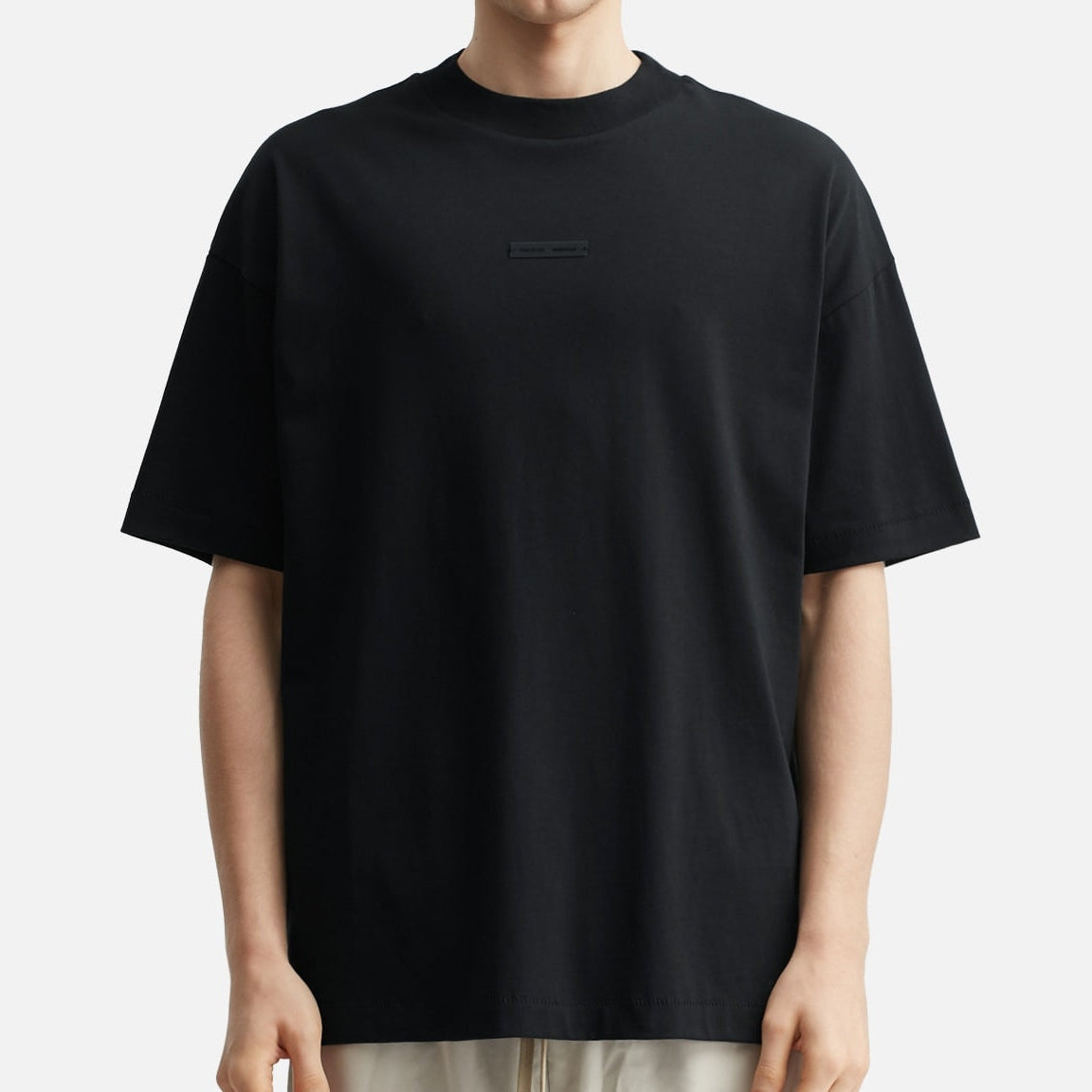 Fear of God Essentials metallic logo black classic T-shirt, black cotton apparel with brand logo detail, front view.