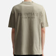 Fear of God Essentials metallic logo classic fit tee in Abbey Stone, showing the soft fabric and subtle logo detail.