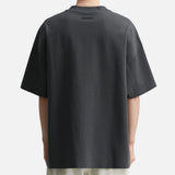 Fear of God Essentials Reflective Logo Ponte 90s Tee in Iron Dark Grey, featuring a reflective logo on a casual, fitted t-shirt.