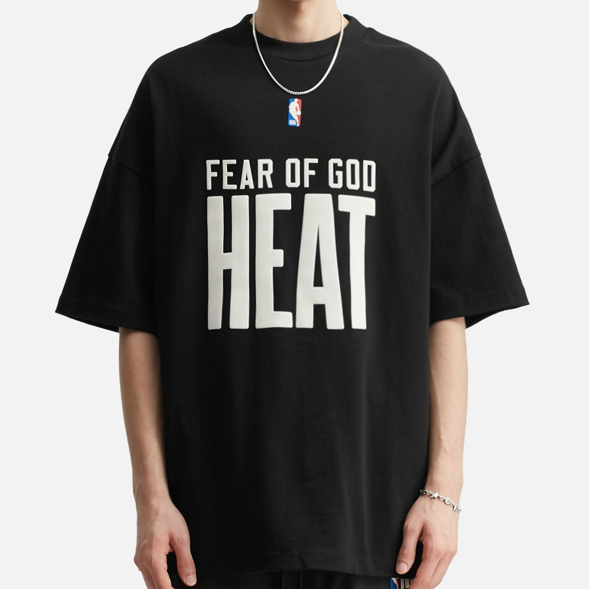 Fear of God Essentials X HEAT NBA 90s heavyweight black T-shirt, casual apparel with bold graphic design, front view.