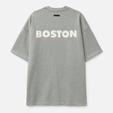 Fear of God Essentials NBA Celtics heavyweight T-shirt in concrete color, featuring Boston Celtics logo and 90s-inspired design.