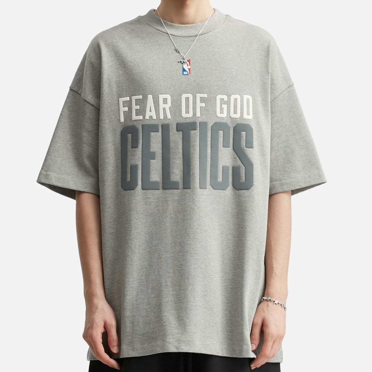 Fear of God Essentials NBA Celtics 90s heavyweight T-shirt in concrete color, featuring team logo and vintage design.
