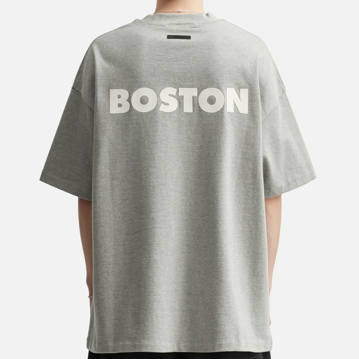Fear of God Essentials NBA Celtics heavyweight T-shirt in concrete color, featuring bold Celtics logo and 90s-inspired design.