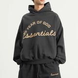 Fear of God Essentials Training 90s Heavyweight Hoodie in iron gray, front view showing relaxed fit and branded logo.