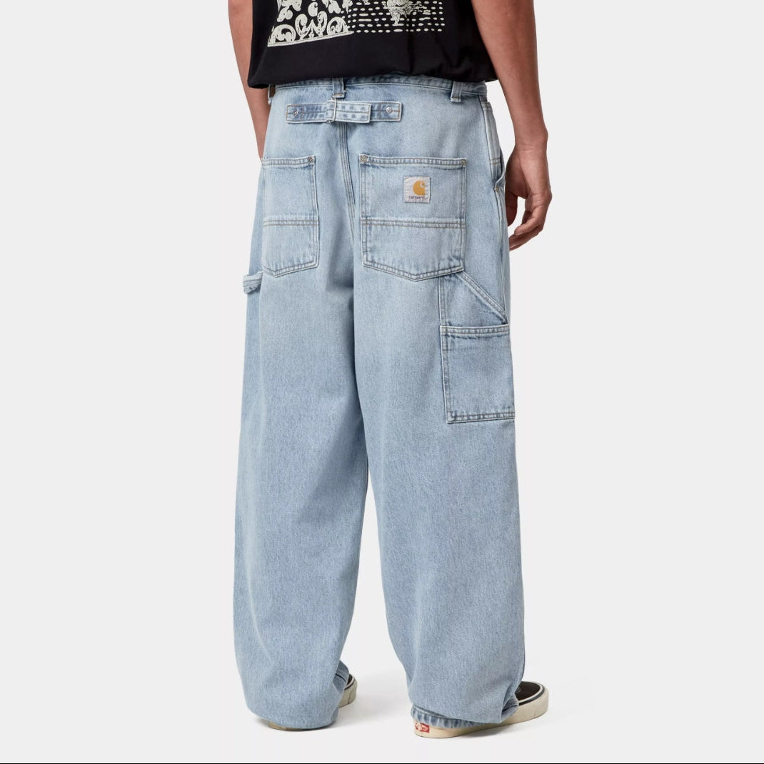 Carhartt WIP Belmont blue pants with a worn, bleached appearance, showing the distressed fabric and casual fit.