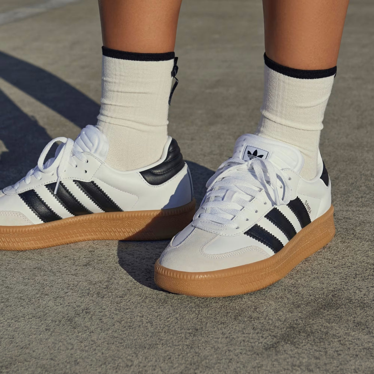 Adidas Originals Samba XLG sneakers in cloud white, core black, and gum color with classic low-top design and rubber sole.