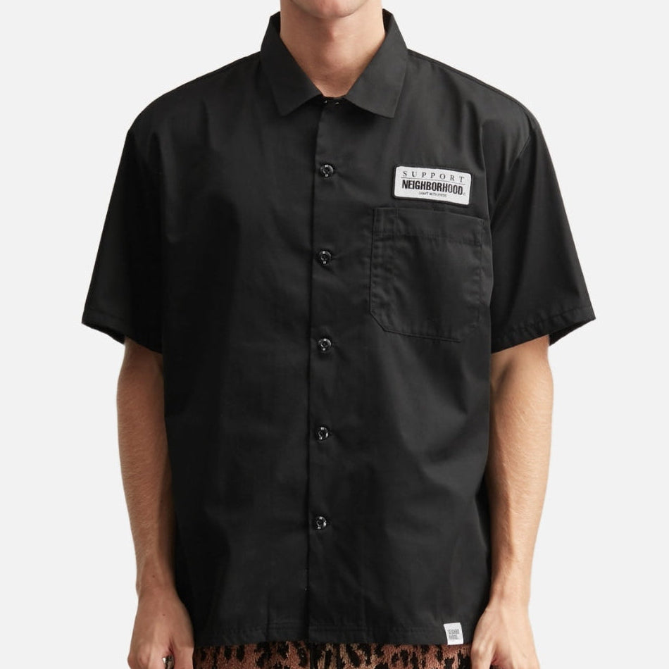Black NEIGHBORHOOD Classic Work short sleeve shirt with button front and collar, displayed on a hanger.
