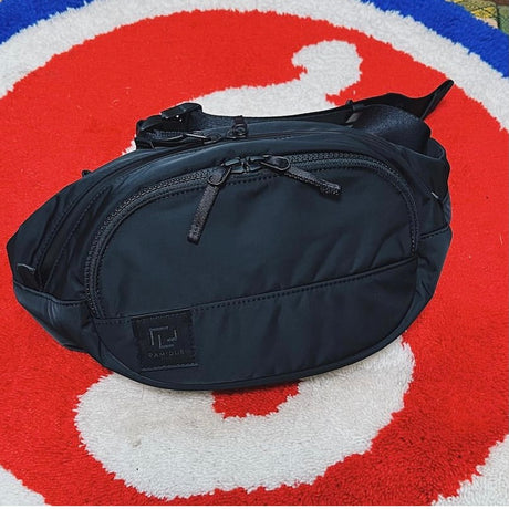 Black Ramidus Japan waist bag with adjustable strap and sleek design, perfect for casual wear and storage.